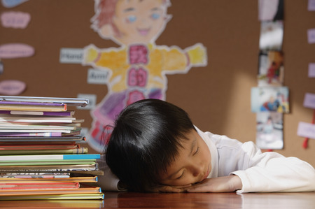 Schoolboy sleeping in classの写真素材