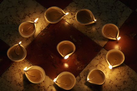 Lit clay oil lamps in a circleの写真素材