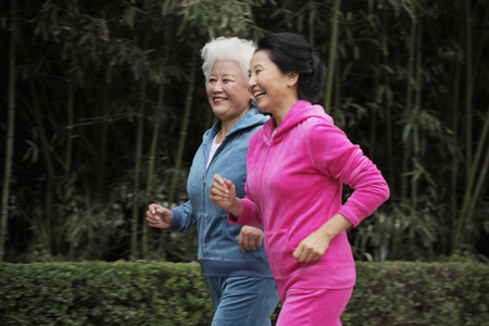 Two older women jogging together
