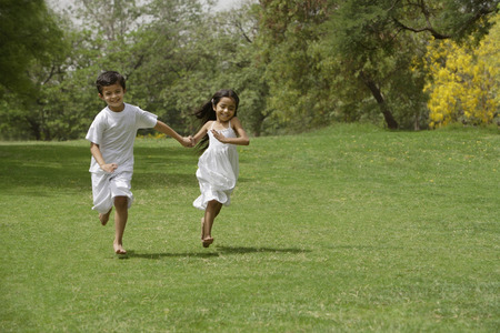 kids running in park, holding handsの写真素材