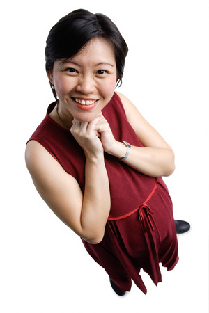 Woman looking at camera, hands clasped under chinの写真素材