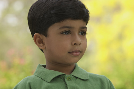 serious little boy wearing green shirtの写真素材