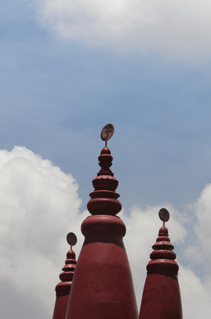 Red turrets of Hindu temple with 'OM' in Sanskrit on top.の写真素材