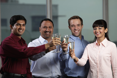 mixed raced group toasting each otherの写真素材