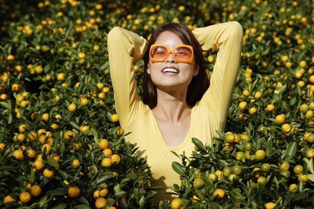 Young woman among orange plantsの写真素材