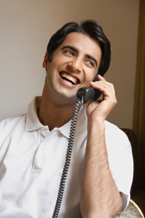 man laughs while talking on phoneの写真素材