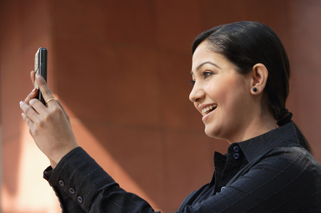woman reading messages, smiling (horizontal)の写真素材
