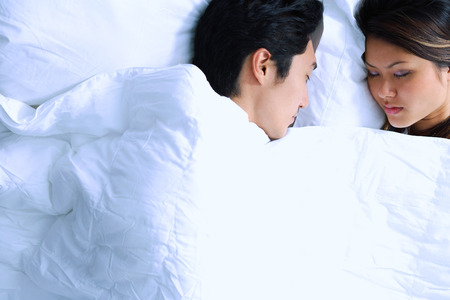 Couple sleeping on bedの写真素材