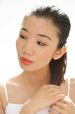 Woman looking away, touching hairの写真素材