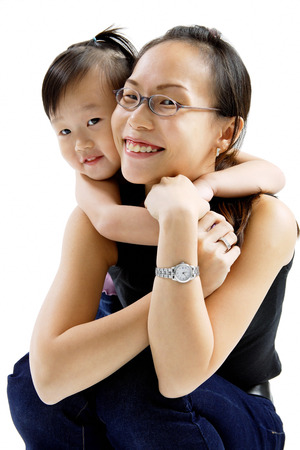 Mother and daughter embracing, smiling at cameraの写真素材