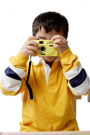 Boy looking through cameraの写真素材
