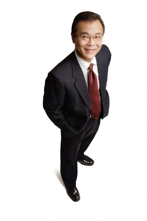 Businessman standing with hands in pocket, smiling at cameraの写真素材