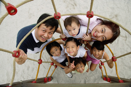 Family at playground, smiling at camera, high angle viewの写真素材