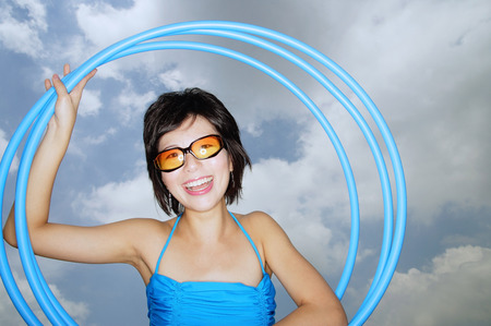 Young woman with sunglasses, holding hoola hoops