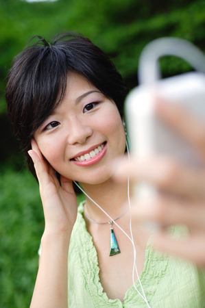 Young woman with mp3 player, smilingの写真素材