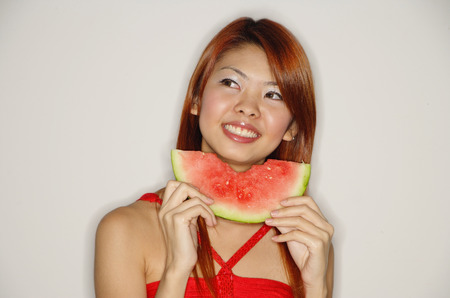 Woman with a slice of watermelon, smilingの写真素材