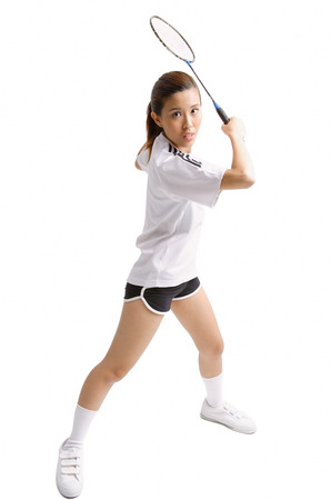 Young woman holding badminton racket, waiting to swingの写真素材