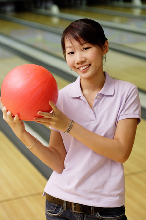 Woman at bowling alley with bowling ballの写真素材