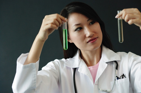 Doctor holding up two test tubesの写真素材