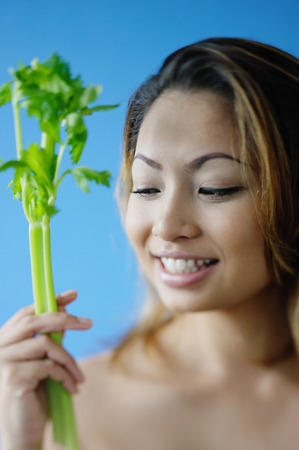 Woman holding a stick of celeryの写真素材