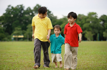 Boys walking on grass, side by sideの写真素材