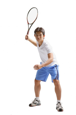 Young man holding tennis racket, waitingの写真素材