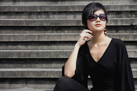 Woman dressed in black, wearing large sunglassesの写真素材