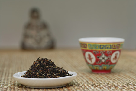 Chinese teacup and plate of tea leaves, still life