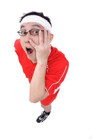 Man in soccer uniform looking at camera, hand on faceの写真素材