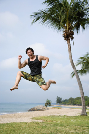 Man jumping in air, looking at cameraの写真素材