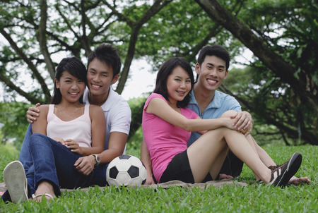 Young adults in park, smiling at cameraの写真素材
