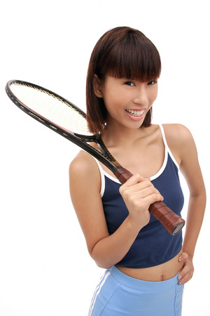 Young woman with tennis racket, smiling at cameraの写真素材
