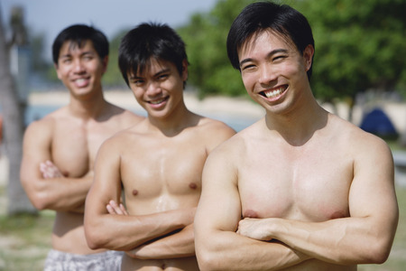 Three shirtless men with arms crossedの写真素材