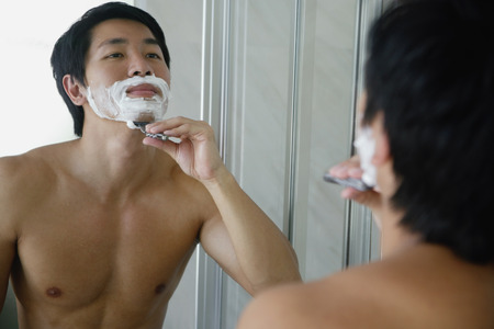 Man looking in mirror, shavingの写真素材