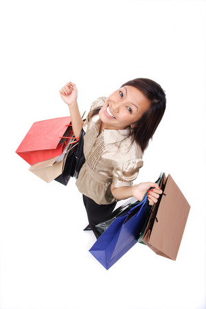Woman carrying shopping bags, looking up at cameraの写真素材