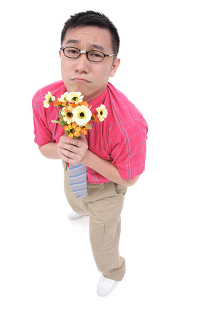 Man in shirt and tie holding flower bouquet, frowningの写真素材