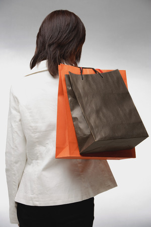 Woman carrying shopping bags, rearviewの写真素材