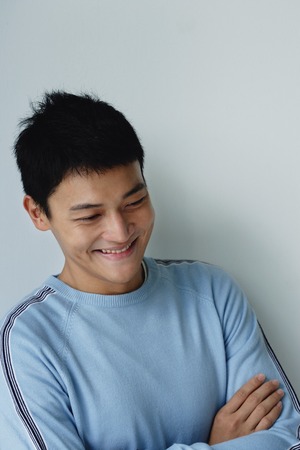 A man crosses his arms and smiles