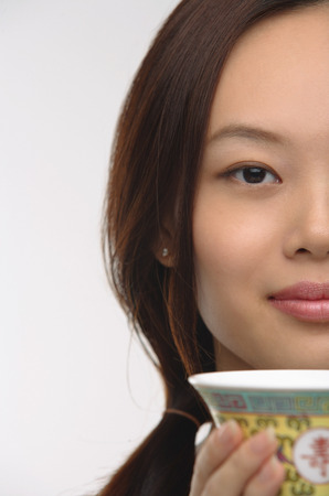 Young woman with traditional tea cup looking at cameraの写真素材