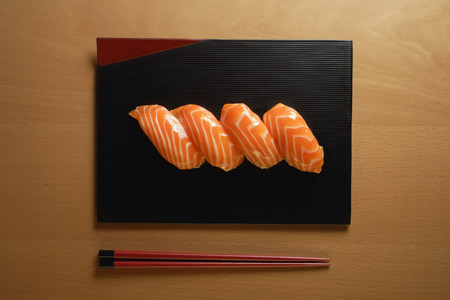 Four pieces of Salmon Sushi, nigiri on rice ball, chopsticksの写真素材