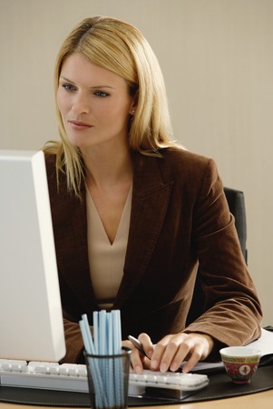 A woman works at her deskの写真素材