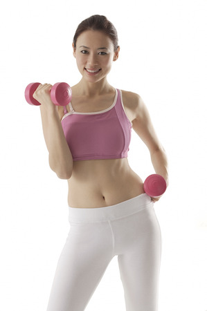 Woman lifting weights, looking at camera, smilingの写真素材