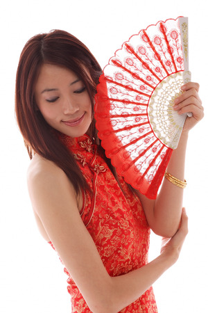 Young woman wearing cheongsam and holding traditional Chinese fanの写真素材