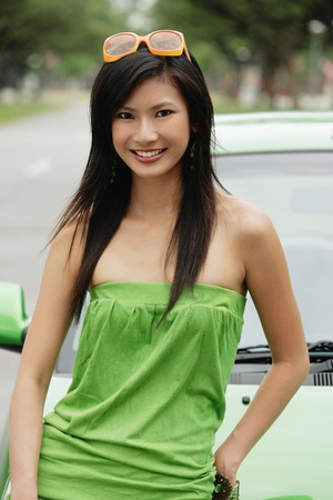 A young woman in a green dress with a green carの写真素材