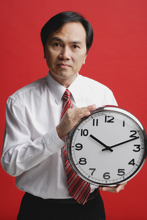 A man holds a clockの写真素材
