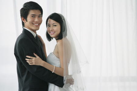 A newlywed couple smile at the cameraの写真素材
