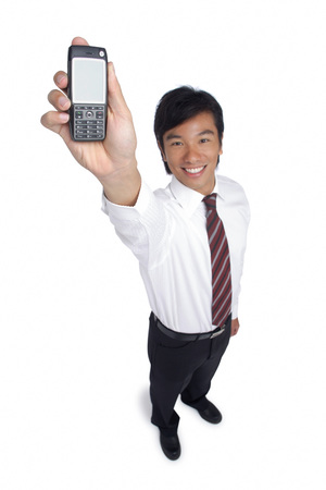 A man smiles at the camera as he holds out his cellphoneの写真素材