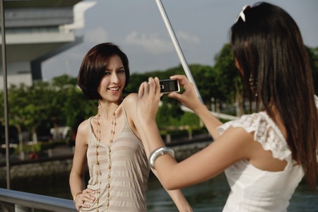 Friends take photos of each other on a bridgeの写真素材