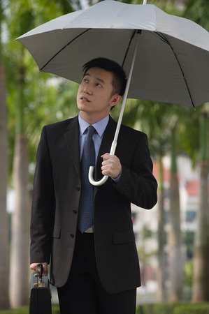 Businessman holding umbrellaの写真素材