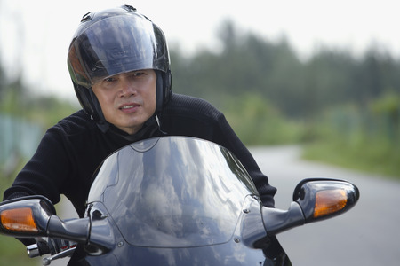 Man wearing helmet and riding motorcycleの写真素材